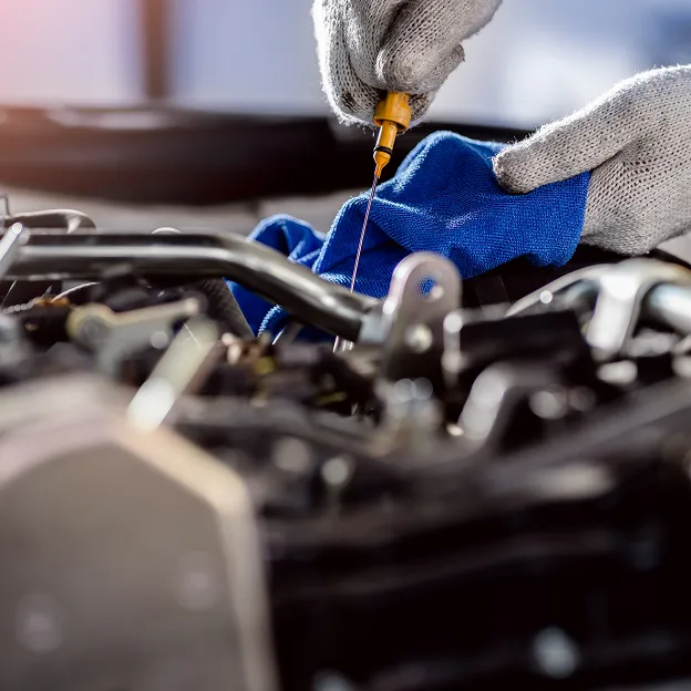 Mécanicien effectuant une réparation précise sur moteur Peugeot avec outil spécialisé.