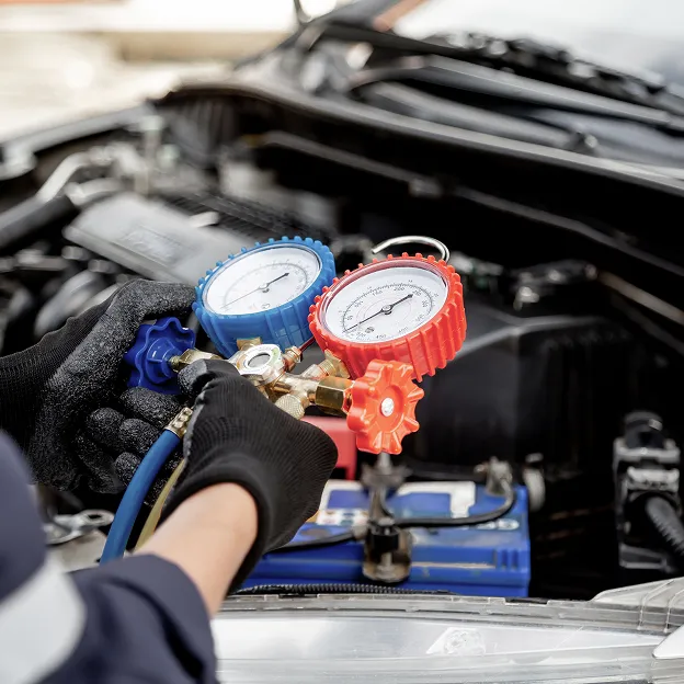 Technicien vérifie pression huile et air dans moteur Peugeot.