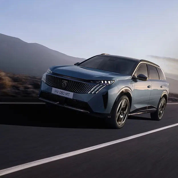 Peugeot SUV hybride en mouvement sur route sinueuse.